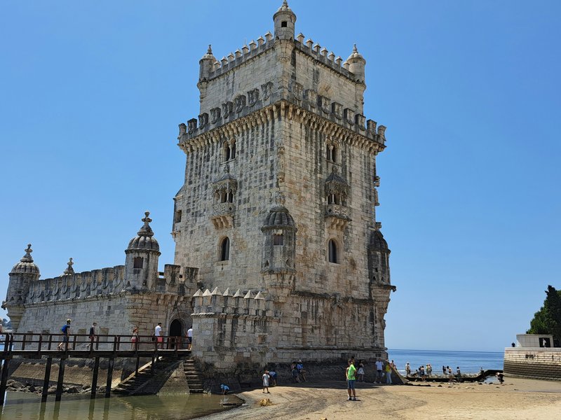 Torre de Belém — the four-storey Manueline limestone tower with its bastion rising from the Tagus estuary at low tide, Lisbon, UNESCO World Heritage since 1983